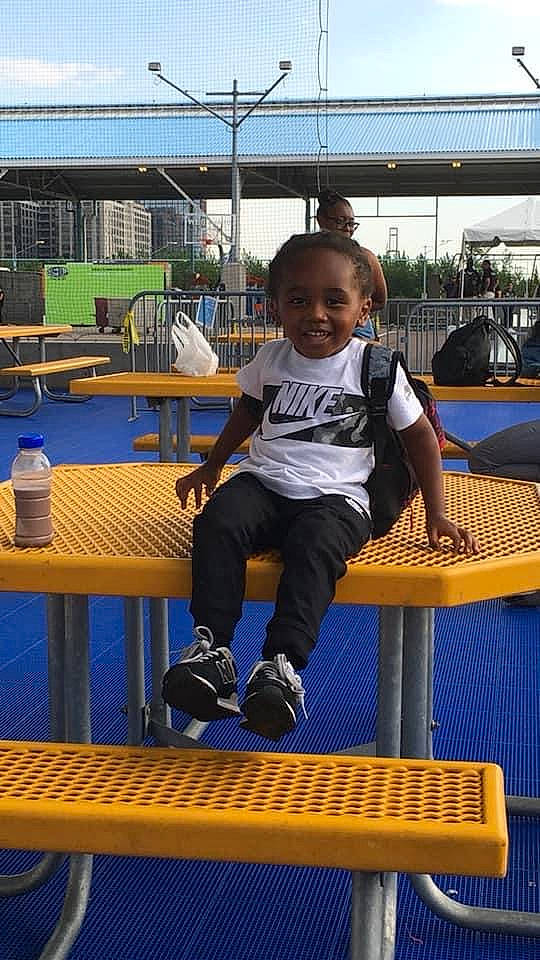 Quamieke Kotto Harris joined the competition — help win amazing prizes! chair, child, city, electric_blue, fun, furniture, joy, leisure, outdoor_furniture, outdoor_table, person, recreation, room, shade, shorts, sitting, sky, smile, sneakers, t_shirt