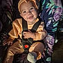 baby, child, car_seat, seatbelt, headband, bow, smile, happy, clothing, onesie, sock, floral_pattern, fabric, indoor, person, cute, infant, sitting, portrait, baby_girl