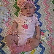 Serenity joined the competition — help win amazing prizes! baby, pink, headband, flower, toy, unicorn, blanket, zigzag_pattern, socks, onesie, infant, cute, child, lying_down, colorful, playful, indoors, soft_texture, happy, portrait