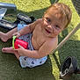 bare_chest, bucket, child, cute, grass, happy, outdoor, person, play, plush_toy, sandal, shadow, shorts, sitting, smiling, stroller, sunlight, toddler, toy, wheel