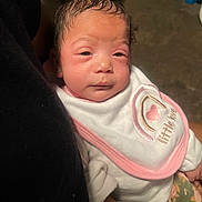 Kalani is registered to the contest to win money with this photo: baby, infant, bib, clothing, pink, white, face, person, sleepy, newborn, cute, child, holding, portrait, indoor, skin, hair, expression, soft, comfort