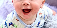 Oliver joined the competition — help win amazing prizes! baby, infant, smiling, blue_eyes, dinosaur_print, onesie, blanket, pillow, soft_texture, happy, cute, child, portrait, indoors, closeup, young, playful, cheerful, crawling, bright