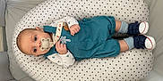 Elio a rejoint le concours — aidez-le/la à gagner de superbes lots ! baby, child, clothing, comfort, cushion, cute, footwear, head, indoor, infant, looking, lying_down, overalls, pacifier, playpen, resting, small_hands, sneakers, soft_lighting, star_pattern
