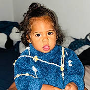 Joseph a rejoint le concours — aidez-le/la à gagner de superbes lots ! toddler, child, blue_sweater, curly_hair, topknot, indoors, holding_object, jar, seashell_pattern, cozy_clothing, expressive_eyes, portrait, soft_lighting, cute, person, baby, sitting, focused, fuzzy_texture, home
