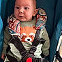 Leo a rejoint le concours — aidez-le/la à gagner de superbes lots ! baby, child, stroller, safety_harness, cute, wide_eyes, smile, infant, clothing, patterned, fabric, blue, red, black, seat, straps, portrait, indoor, person, young