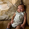 baby, blue_socks, child, comfort, couch, cozy, cute, dinosaur_print, expression, happy, indoors, infant, leather, onesie, pillow, portrait, relax, seated, skin, smile