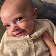 Basilia a rejoint le concours — aidez-le/la à gagner de superbes lots ! baby, beige_clothing, blurred_background, child, christmas_tree, closeup, cozy, cute, eyes, face, hand, holiday_decorations, indoor, infant, knitted_sweater, newborn, person, portrait, smiling, warm