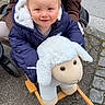 Lino participe au concours pour gagner de l'argent avec cette photo : adult, child, cute, face, fun, happy, head, jacket, outdoor, pavement, person, play, plush_toy, rocking_toy, sheep, smile, street, toddler, toy, winter_clothing
