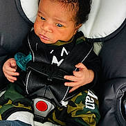 Chosen joined the competition — help win amazing prizes! baby, infant, car_seat, pacifier, clothing, camo_pants, socks, seatbelt, child, person, face, hand, indoor, cute, expression, black_hair, safety, portrait, newborn, closeup