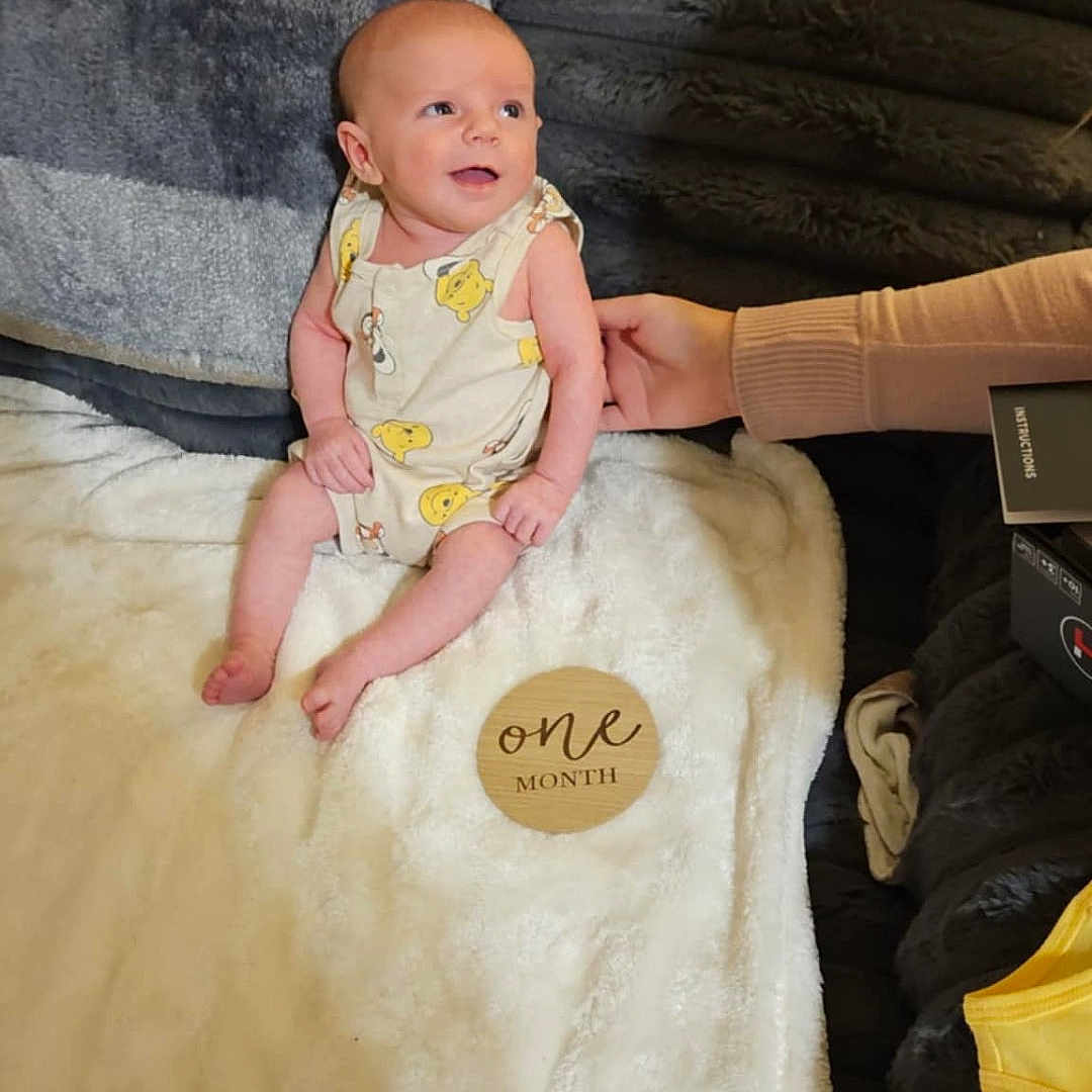 Ryder is registered to the contest to win money with this photo: baby, bed, bedroom, blanket, clothing, couch, cushion, dress, face, furniture, head, homedecor, indoors, newborn, pants, person, photography, portrait, quilt, room