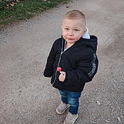 Mayron a rejoint le concours — aidez-le/la à gagner de superbes lots ! child, toddler, boy, lollipop, jacket, jeans, sneakers, standing, path, fence, grass, outdoor, smile, face, portrait, hood, ground, walking, daylight, cute