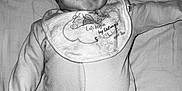 Cody is registered to the contest to win money with this photo: baby, infant, onesie, bib, smile, face, lying_down, bed, sleepwear, cute, child, monochrome, black_and_white, portrait, young, happy, skin, head, expression, person