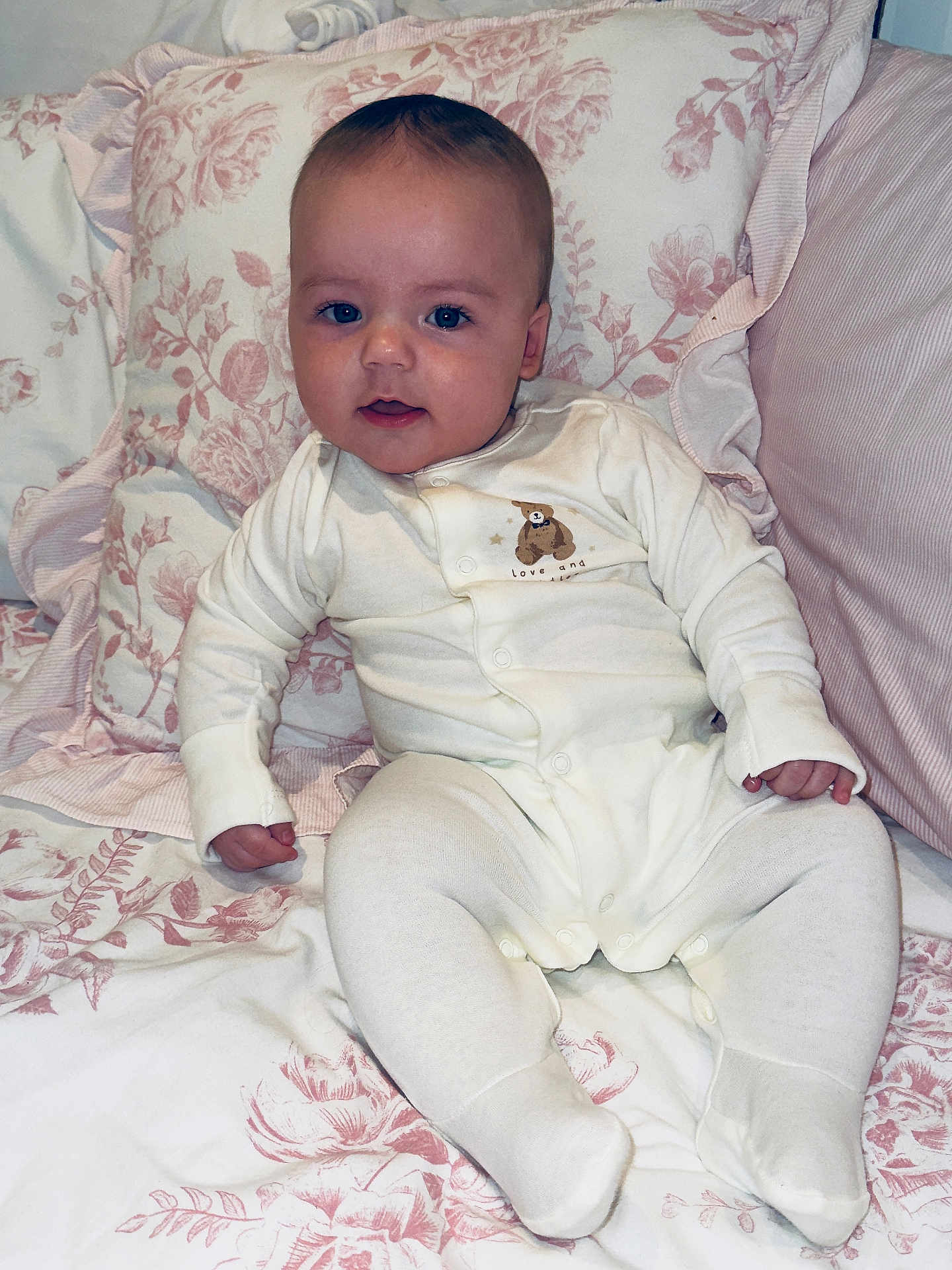 Cody joined the competition — help win amazing prizes! baby, infant, onesie, bed, pillow, floral_pattern, blue_eyes, smile, cute, cozy, sleepwear, blanket, indoors, child, person, soft, comfort, resting, young, portrait