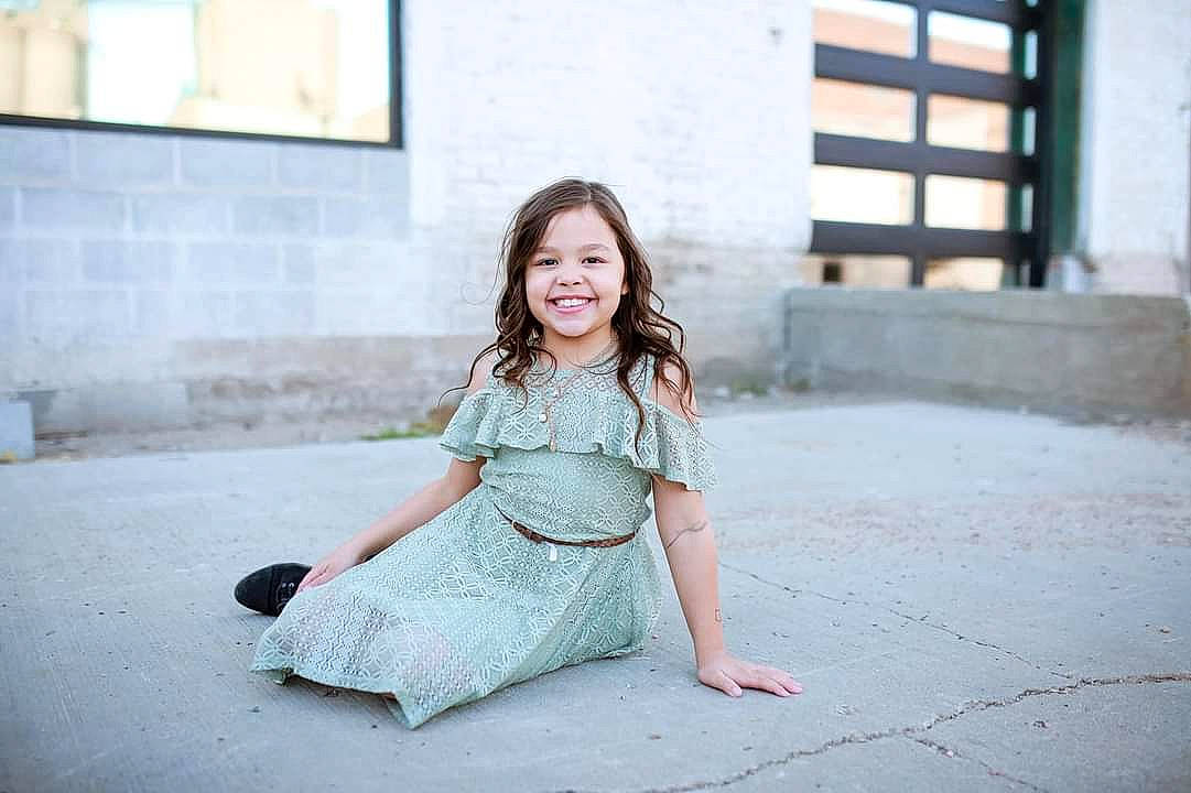 Kiyalyn is registered to the contest to win money with this photo: baby_toddler_clothing, child_model, day_dress, dress, facial_expression, floor, happy, joy, laugh, mouth, nose, one_piece_garment, pattern, person, photograph, portrait_photography, sitting, sleeve, snapshot, street_fashion
