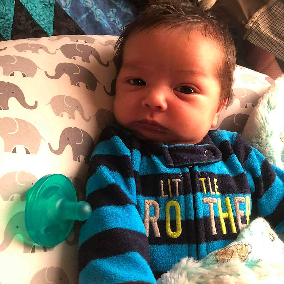 Bryxton is registered to the contest to win money with this photo: aqua, baby, baby_products, baby_toddler_clothing, baby_toys, cheek, child, comfort, cool, eyelash, knitting, linens, person, plastic, sweater, teal, textile, toddler, turquoise, wool