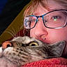 Miso is registered to the contest to win money with this photo: person, cat, glasses, close_up, piercing, blanket, cozy, indoor, face, whiskers, fur, pet, animal, comfort, cuddle, portrait, eyewear, expression, domestic, warmth