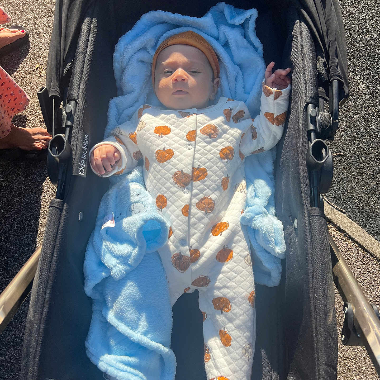 Tejas joined the competition — help win amazing prizes! baby, baby_clothes, barefoot, blanket, child, clothing, cute, daytime, footwear, headwear, infant, onesie, outdoor, person, pumpkin_pattern, relaxing, sidewalk, stroller, sunlight, warm