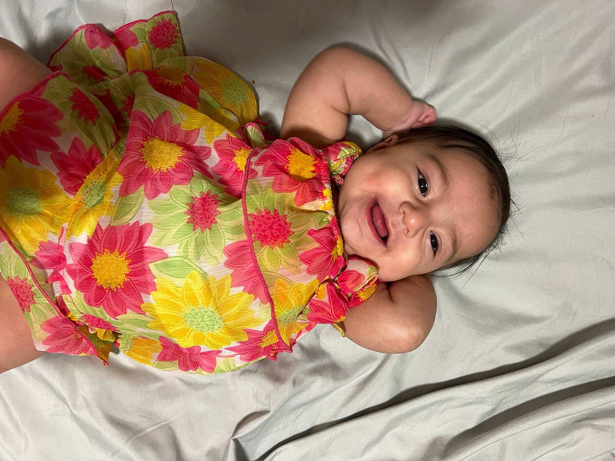 Nyla is registered to the contest to win money with this photo: baby, baby_products, baby_toddler_clothing, child, comfort, dress, eye, face, flower, happy, head, human_body, human_leg, linens, pattern, person, petal, room, skin, smile