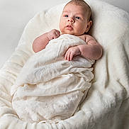Eli joined the competition — help win amazing prizes! baby, infant, blanket, white, soft, cushion, face, skin, newborn, cute, child, person, indoors, portrait, resting, swaddled, hand, head, expression, comfort