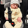 newborn, baby, sleeping, car_seat, infant, child, portrait, indoors, safety_harness, seatbelt, hat, onesie, fleece, cream_clothing, teddy_bear, vehicle, cozy, peaceful, resting, close_up