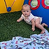 baby, child, crawling, onesie, playground, artificial_grass, blanket, footprints, colorful, yellow, blue, circular_windows, indoor_play_area, infant, cute, toddler, person, young_child, playtime, soft_surface