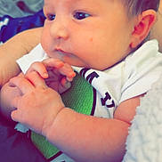 Sophia is registered to the contest to win money with this photo: baby, infant, closeup, face, hands, onesie, clothing, skin, eyes, expression, newborn, person, child, cute, soft, cozy, blanket, portrait, indoors, human