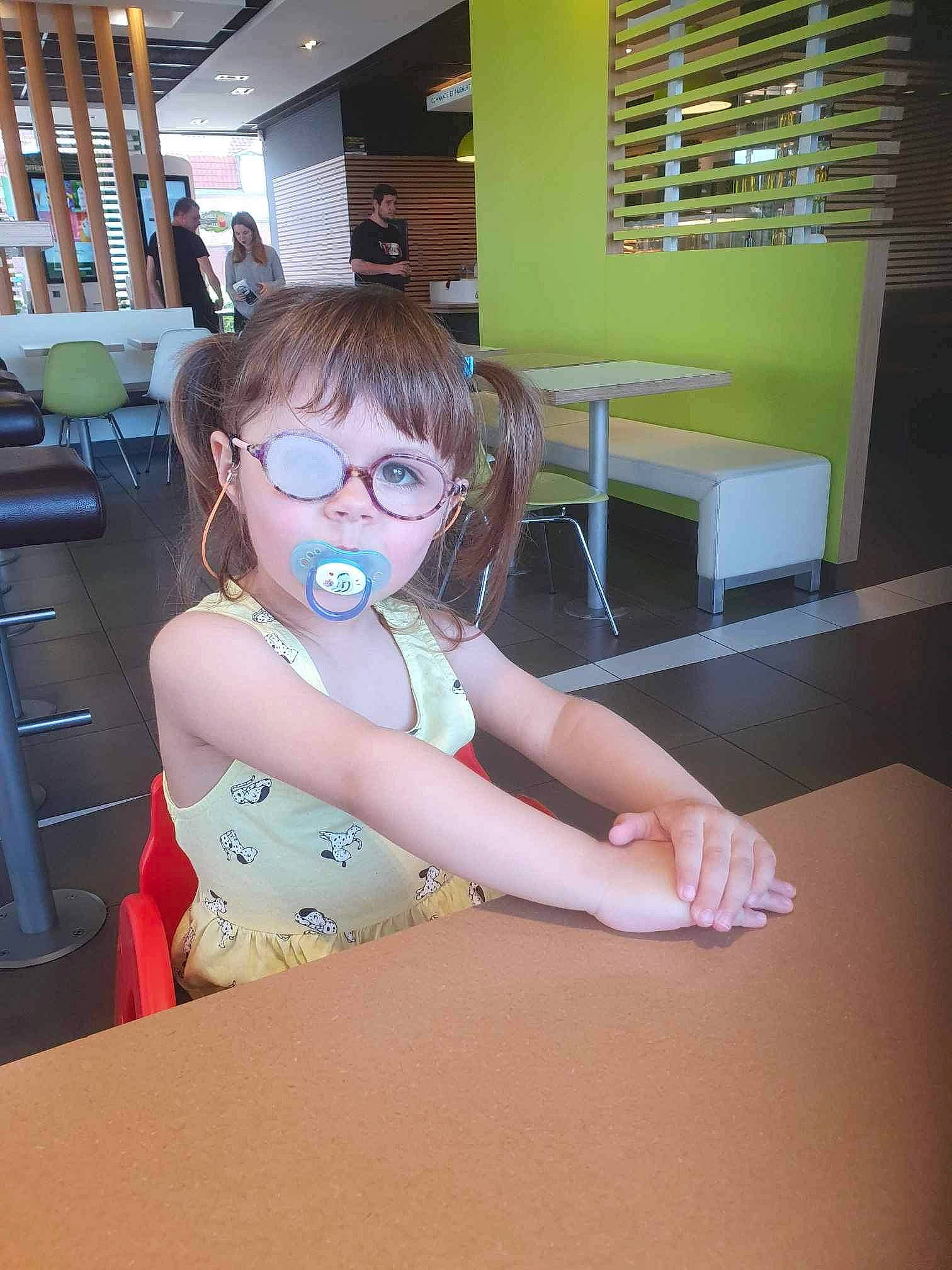 Maëlya participe au concours pour gagner de l'argent avec cette photo : cabinetry, chair, desk, drawer, eyewear, floor, flooring, fun, glasses, goggles, human_leg, person, room, shelf, shoulder, table, thumb, toddler, vision_care, window_blind
