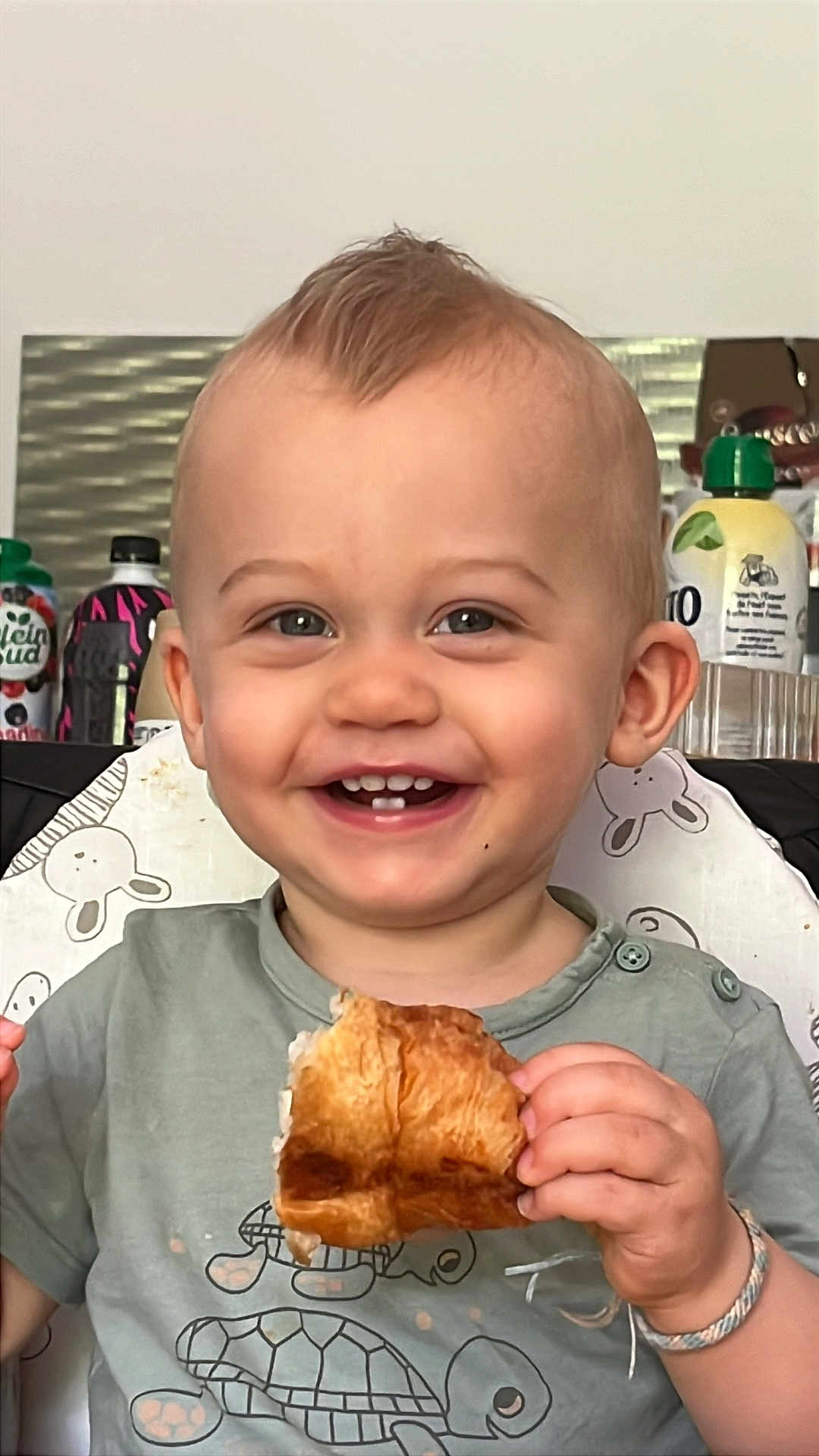 Giulliano a rejoint le concours — aidez-le/la à gagner de superbes lots ! toddler, child, smiling, happy, croissant, food, eating, face, hair, moawk, kitchen, background, sitting, highchair, clothing, bracelet, portrait, cute, indoor, breakfast