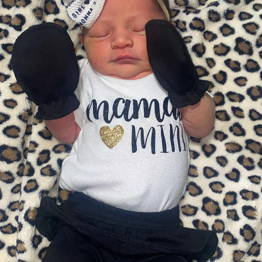 Cynsleigh is registered to the contest to win money with this photo: baby, black_pants, blanket, bow, clothing, cozy, cute, headband, infant, leopard_print, lying_down, mittens, newborn, peaceful, portrait, sleeping, small_hands, soft_texture, text_on_clothing, white_shirt