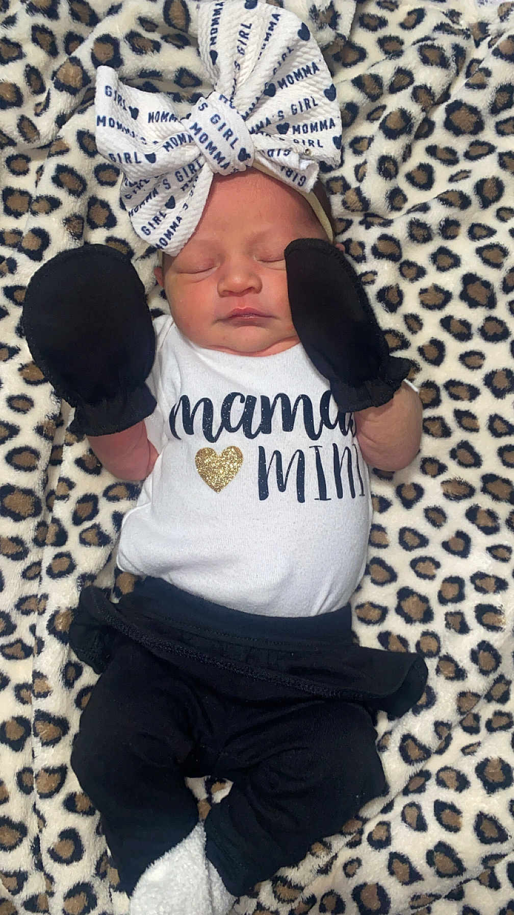Cynsleigh is registered to the contest to win money with this photo: baby, black_pants, blanket, bow, clothing, cozy, cute, headband, infant, leopard_print, lying_down, mittens, newborn, peaceful, portrait, sleeping, small_hands, soft_texture, text_on_clothing, white_shirt