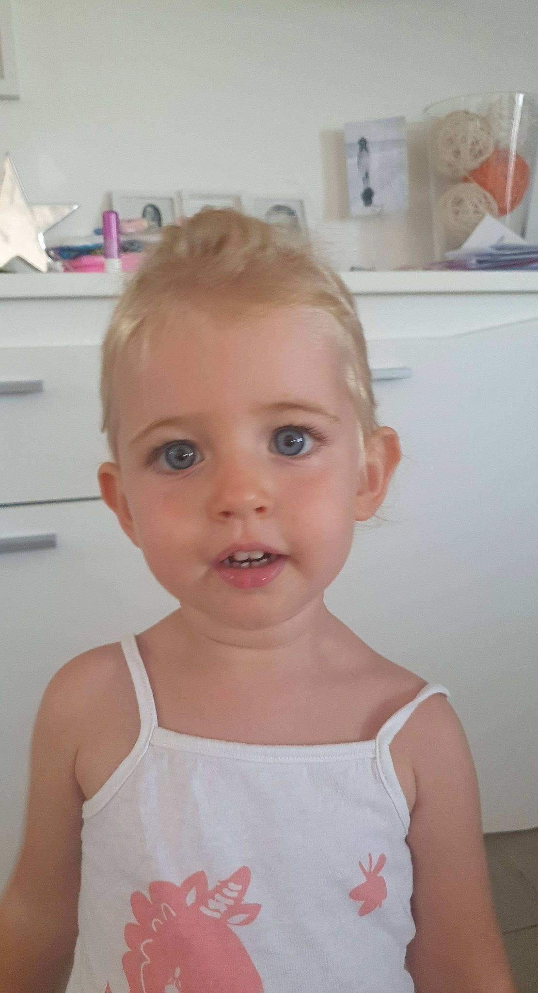 Mila participe au concours pour gagner de l'argent avec cette photo : baby, blond, cheek, child, chin, eyebrow, face, facial_expression, forehead, hair, hairstyle, head, lip, nose, person, pink, shoulder, skin, smile, standing