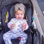 Kaylani joined the competition — help win amazing prizes! baby, child, stroller, onesie, headband, bow, smiling, happy, outdoor, sidewalk, road, clothing, infant, person, seatbelt, carseat, cute, face, hands, playful