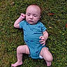 Anthony is registered to the contest to win money with this photo: baby, infant, grass, blue_onesie, dinosaur_pattern, outdoor, nature, lying_down, child, person, cute, skin, hand, foot, expression, young, one_person, casual_clothing, daylight, greenery