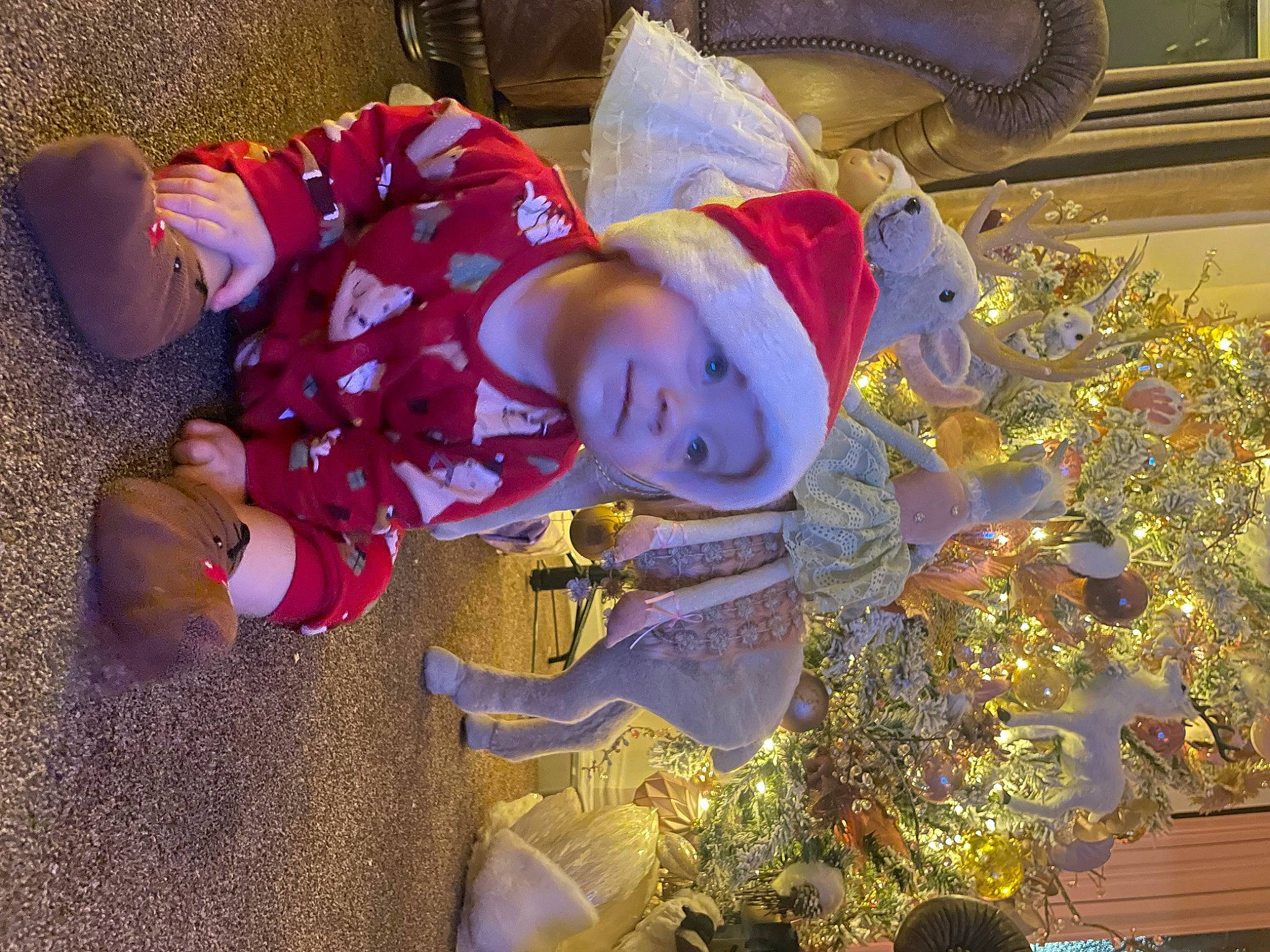 Darcy is registered to the contest to win money with this photo: baby, baby_toddler_clothing, child, christmas, christmas_decoration, christmas_eve, christmas_tree, event, fictional_character, fun, happy, hat, headwear, holiday, interior_design, ornament, person, plant, smile, toddler