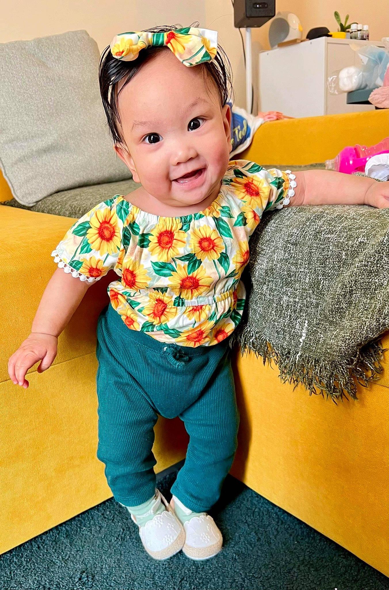 Breanna is registered to the contest to win money with this photo: baby, baby_toddler_clothing, cheek, child, costume, face, floor, flooring, fun, happy, head, leisure, pattern, person, purple, room, sitting, sleeve, smile, t_shirt