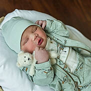 Reign joined the competition — help win amazing prizes! baby, bed, blanket, bodypart, bonnet, cap, clothing, cradle, crib, face, finger, furniture, hand, hardwood, hat, head, newborn, person, sleeping, wood
