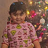 child, pajamas, grinch, christmas_tree, holiday_lights, water_bottle, smile, indoor, festive, decorations, holiday, cute, person, young_child, celebration, christmas, lighting, standing, hair_clips, fun