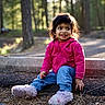 blue_jeans, casual_clothing, child, cute, daylight, fluffy_slippers, forest, ground, happy, nature, outdoor, pine_needles, pink_hoodie, playful, portrait, sitting, smiling, sunlight, toddler, young_child