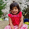 Nidhira Avirneni is registered to the contest to win money with this photo: bracelet, casual, child, cute, daylight, feet, floral_pants, flowering_tree, ground, happy, nature, outdoor, playful, portrait, red_clothing, sitting, smile, toddler, tree, young_child