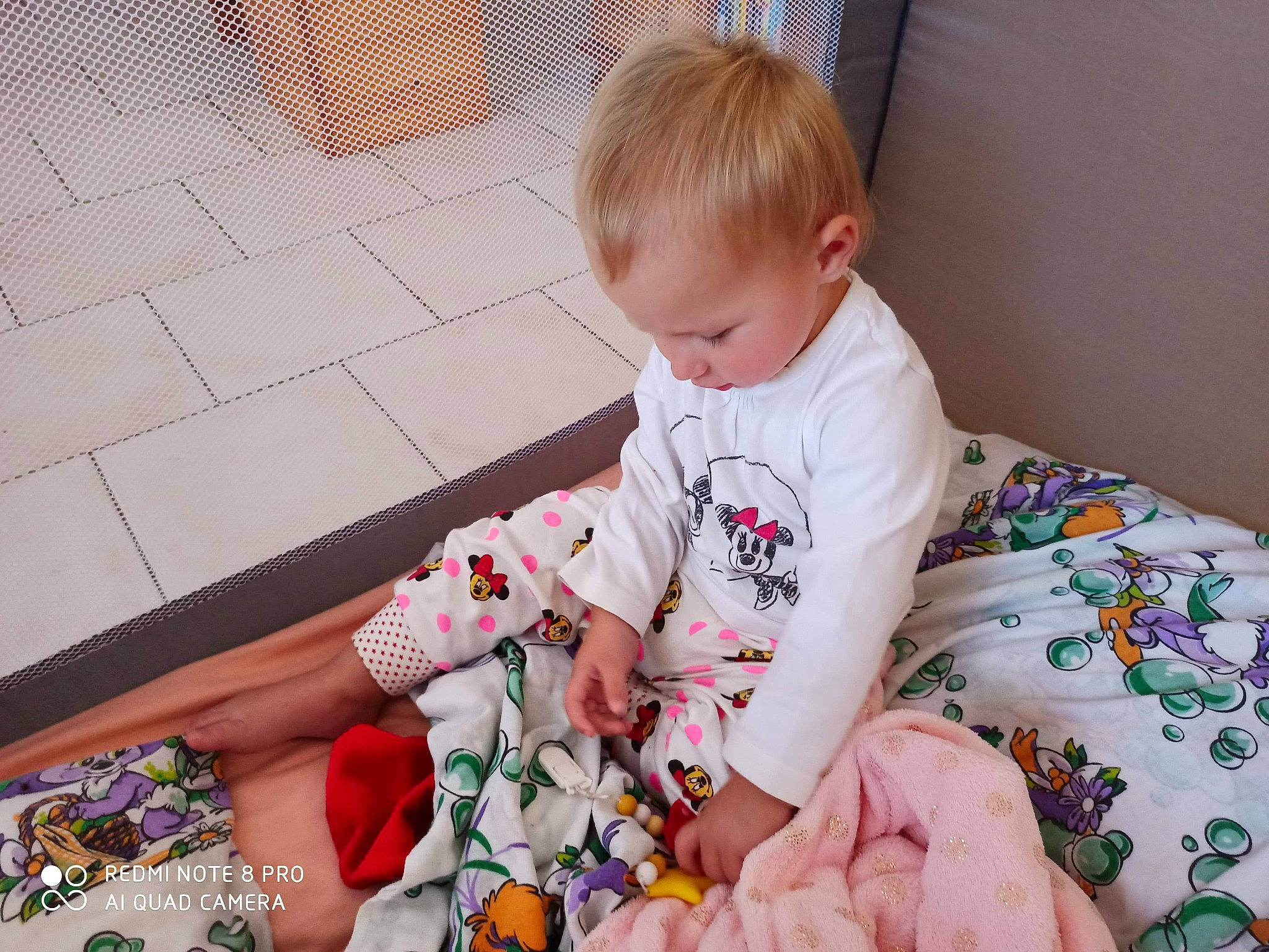 Youssera a rejoint le concours — aidez-le/la à gagner de superbes lots ! baby, baby_toddler_clothing, bed_sheet, blond, child, comfort, curious, floor, flooring, foot, hand, lap, linens, nightwear, pajamas, person, play, sock, tile, toddler