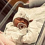 baby, newborn, pacifier, hat, blanket, sleeping, hospital, bassinet, white_clothing, knitted_hat, infant, cute, peaceful, indoors, soft_light, closeup, tiny_hand, cozy, portrait, child