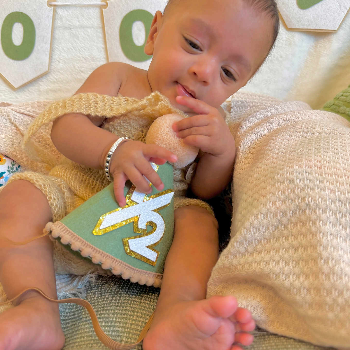 Daksh joined the competition — help win amazing prizes! baby, infant, child, portrait, sitting, smiling, curious, blanket, couch, plush_toy, toy, milestone, banner, indoor, cozy, barefoot, bracelet, soft_lighting, close_up, family_photo