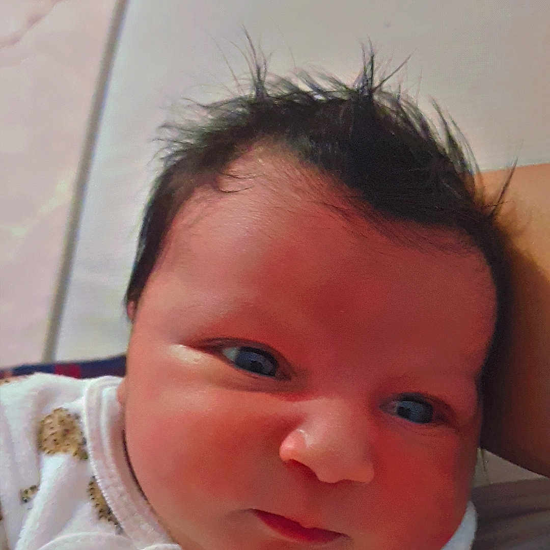 Layth a rejoint le concours — aidez-le/la à gagner de superbes lots ! baby, child, closeup, clothing, cute, expression, eyes, face, hair, head, indoors, infant, lying_down, newborn, patterned_clothing, portrait, skin, soft, white_outfit, young