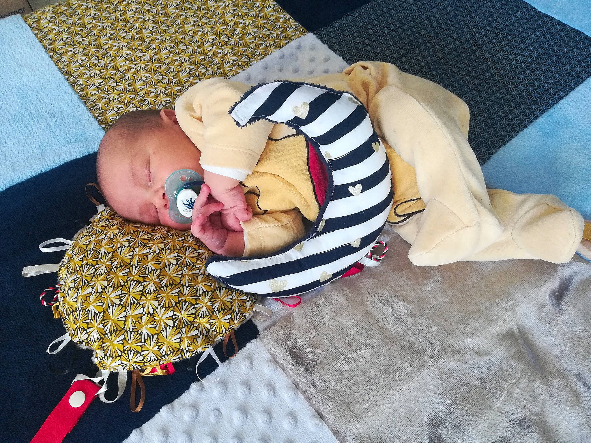 Marius participe au concours pour gagner de l'argent avec cette photo : baby, baby_products, baby_sleeping, baby_toddler_clothing, bedding, bedtime, child, comfort, fashion_accessory, flooring, headgear, linens, nail, nap, pattern, person, room, stuffed_toy, sunglasses, textile