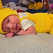 Caspian joined the competition — help win amazing prizes! baby, infant, yellow_knit, knitted_hat, knitted_outfit, lying_down, soft_surface, cute, small_hands, face, indoors, cozy, colorful_background, child, newborn, portrait, sleepy, resting, warm_clothing, closeup