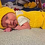 baby, infant, yellow_knit, knitted_hat, knitted_outfit, lying_down, soft_surface, cute, small_hands, face, indoors, cozy, colorful_background, child, newborn, portrait, sleepy, resting, warm_clothing, closeup