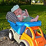 Lennox is registered to the contest to win money with this photo: baby, newborn, toy_truck, outdoor, grass, trees, greenery, blanket, cap, infant, cute, child, sunlight, nature, plastic_toy, playful, relaxing, summer, small, portrait