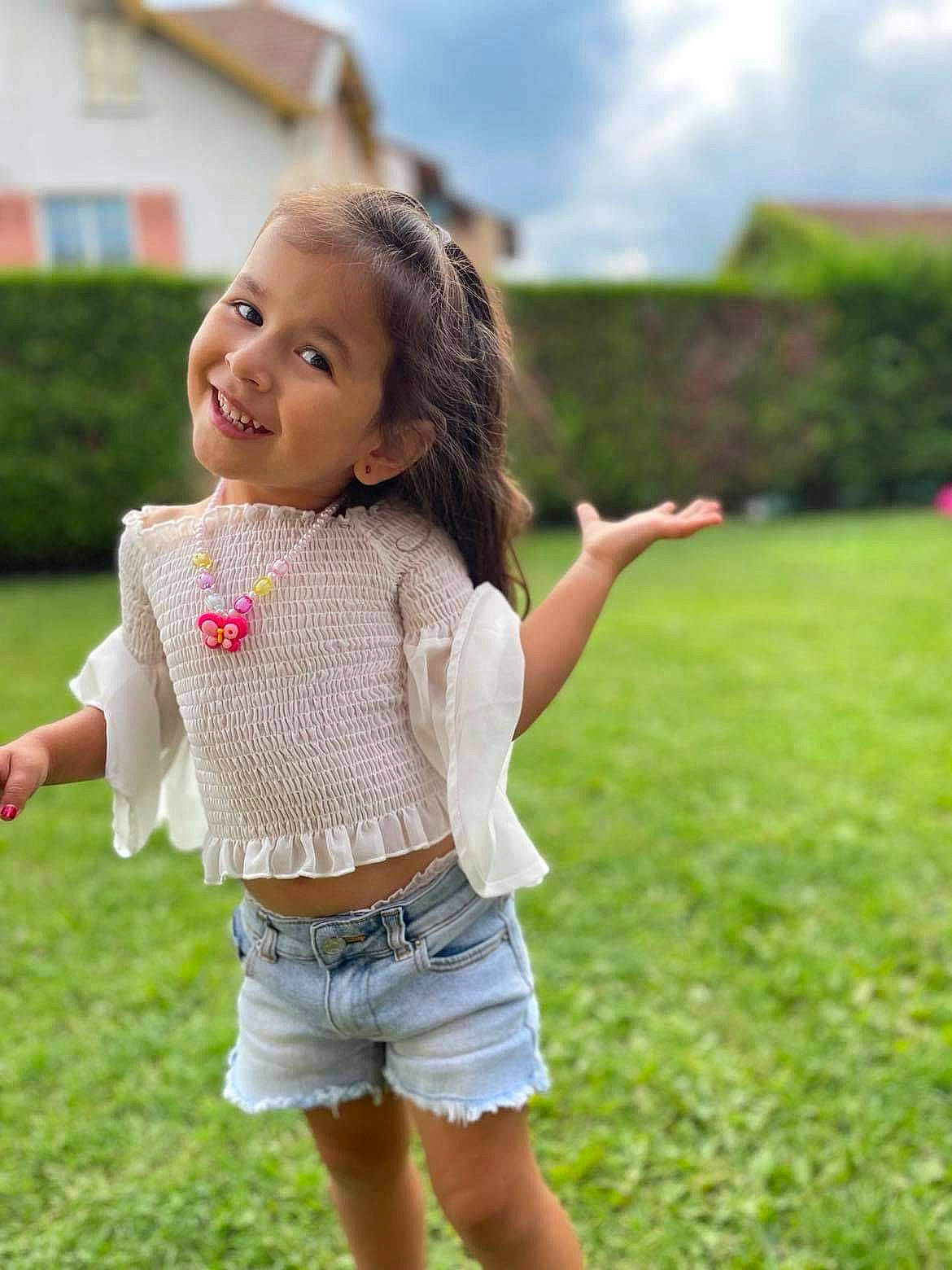 Maddy participe au concours pour gagner de l'argent avec cette photo : face, gesture, grass, green, hair, hand, happy, head, jean_short, joy, leg, leisure, people_in_nature, person, plant, shorts, skin, sky, smile, toy