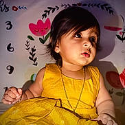 Ayura joined the competition — help win amazing prizes! toddler, child, yellow_dress, gold_chain, curly_hair, indoor, portrait, cute, baby, expression, wall_art, flower, numbers, sitting, bright_color, skin, hand, face, young_child, decor