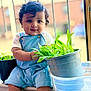 Ayura joined the competition — help win amazing prizes! toddler, child, baby, overalls, plants, pot, windowsill, curly_hair, greenery, indoor, bracelet, shorts, cute, portrait, natural_light, window, sitting, curious, young_child, casual_clothing